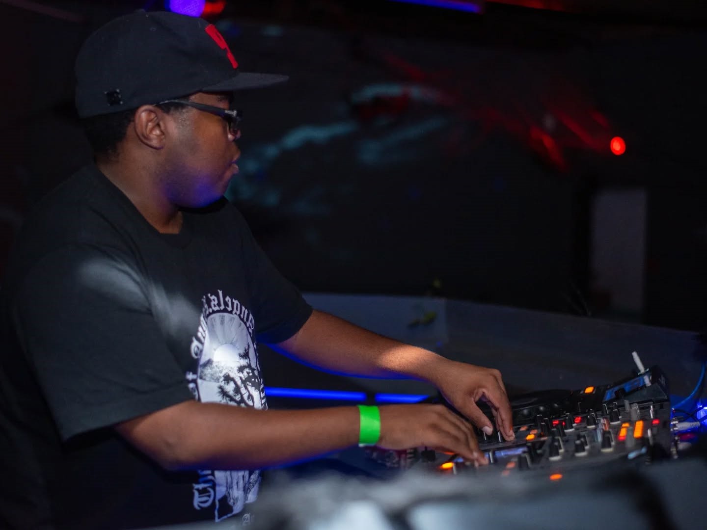 Live performance stage setup with mixer faders and energetic crowd lighting