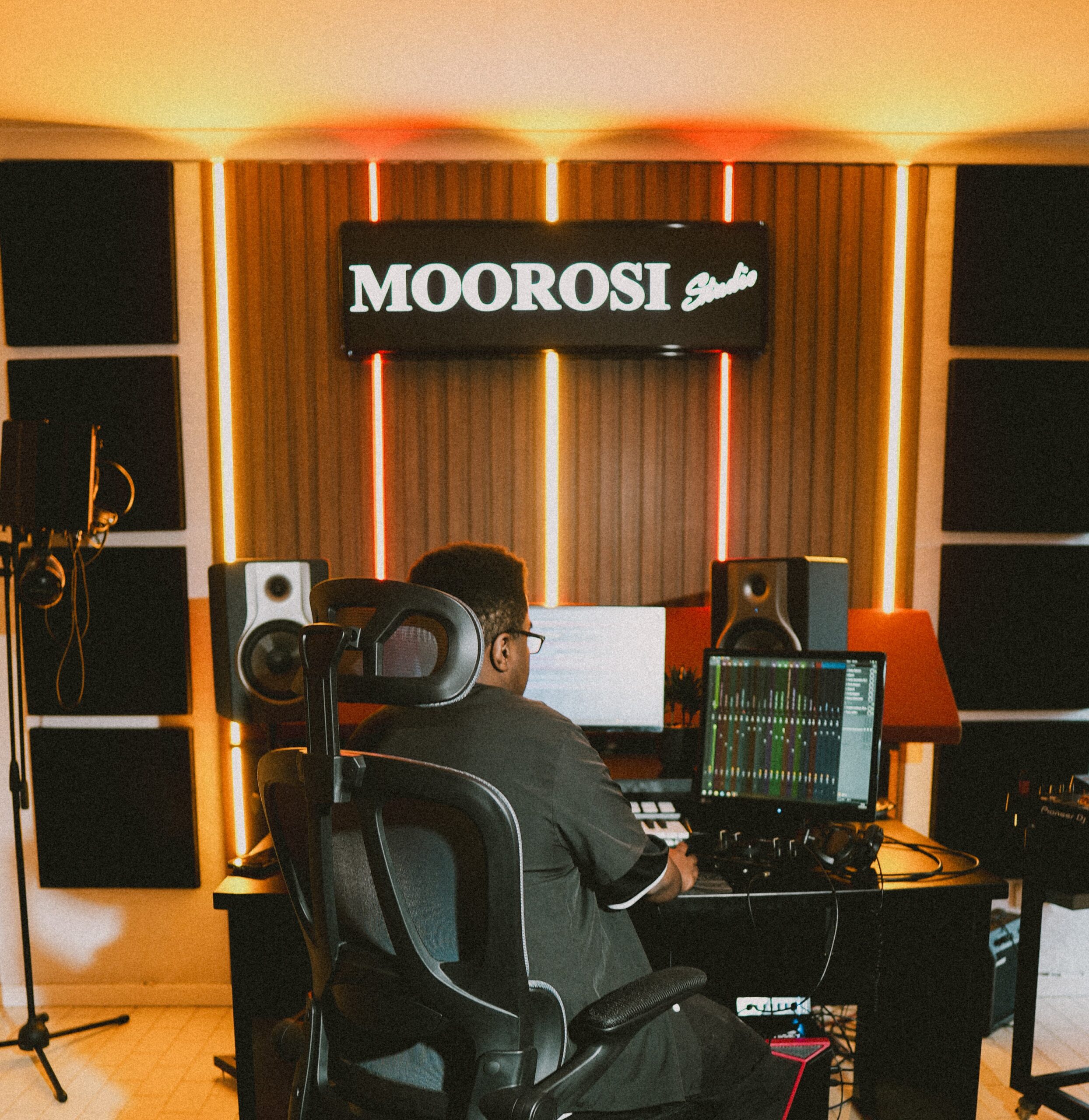 Student arranging music on an audio workstation with studio monitors