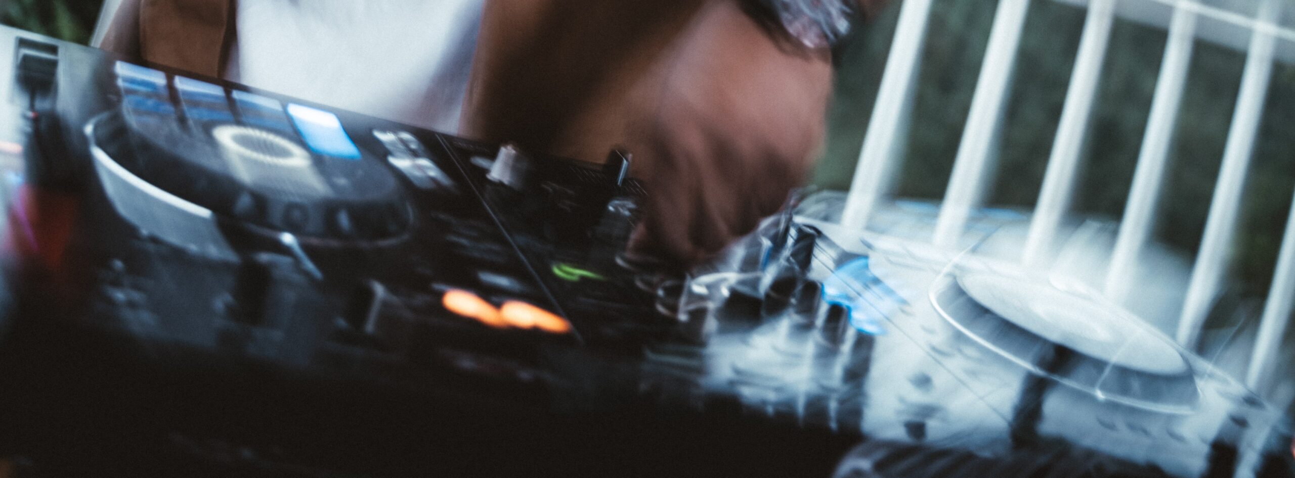 Hands cueing a vinyl record on a turntable in a warm home studio